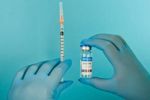 Covid Coronavirus Aşı Şişesi Şırıngayla Kadın Eli Mavi Arka Planda — Stok fotoğraf