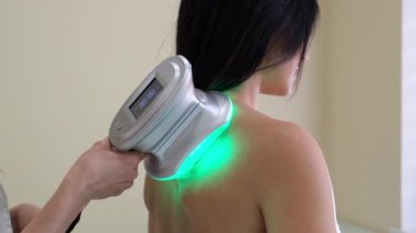 Kadın sırtında özel bir aletle güzellik uzmanı prosedürleri. Yavaş çekim.