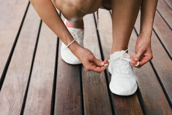 Женщина шнурует спортивную обувь — стоковое фото