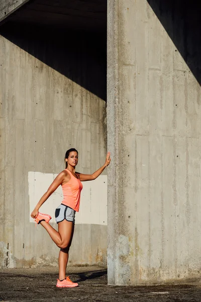 Atleta feminina esticando as pernas para correr — Fotografia de Stock