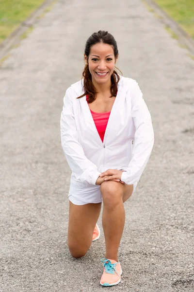 Deportiva mujer de fitness estirando las piernas antes de correr —  Fotos de Stock