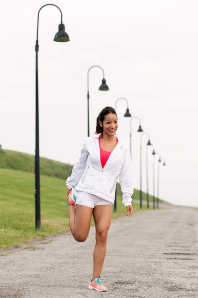 Deportiva mujer de fitness estirando las piernas antes de correr —  Fotos de Stock