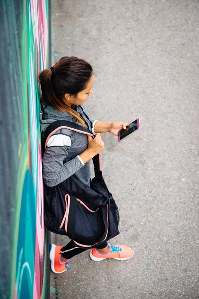 Mujer deportiva urbana mensajes de texto en el teléfono inteligente —  Fotos de Stock