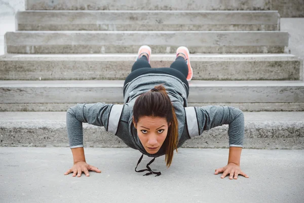 Strong fitness urban woman doing push ups — Stock Photo, Image