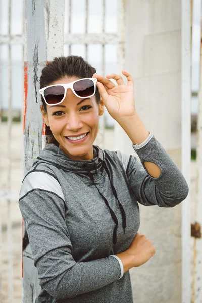 Erfolgreiche Fitness-Frau trägt Sonnenbrille und lächelt — Stockfoto