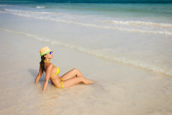 Frau im Strandurlaub sonnt sich am Strand — Stockfoto