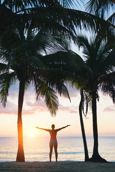 Glückselige Fitness-Frau genießt Strand entspannenden Sonnenuntergang unter Palmen — Stockfoto