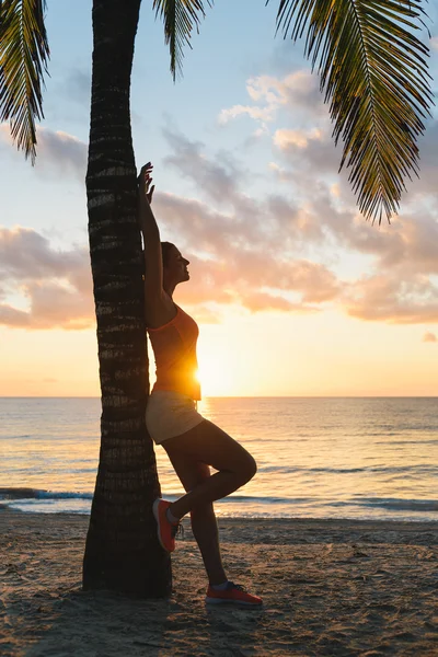 Fitness donna rilassarsi dopo il mattino spiaggia tropicale allenamento — Foto Stock