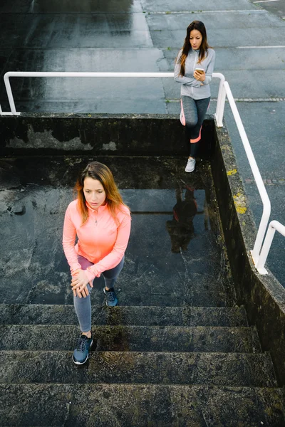 Woman stretching legs on stairs — Stock Photo, Image