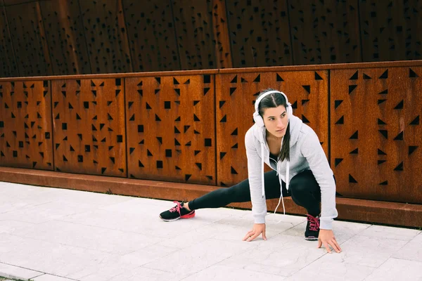 Ung urban fitness kvinna stretching adductors — Stockfoto