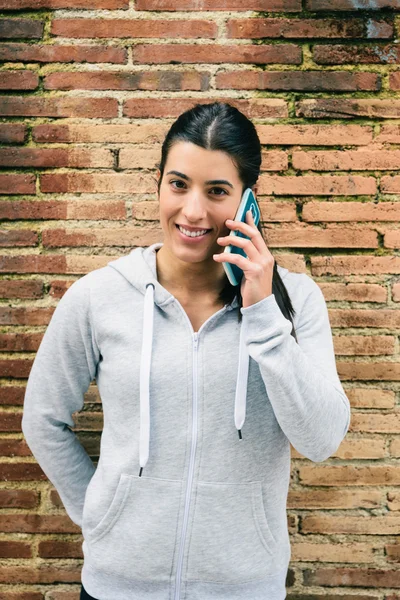 Mulher fitness urbana na chamada smartphone sorrindo — Fotografia de Stock