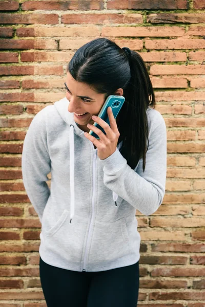 Mujer fitness urbana en el teléfono inteligente llamada sonriendo — Foto de Stock
