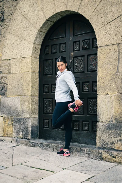 Urban fit female runner stretching — Stock Photo, Image