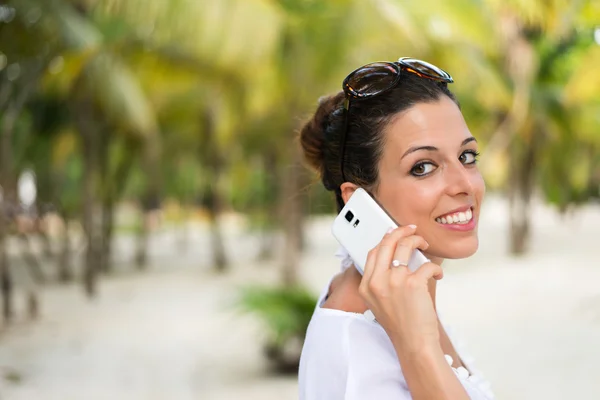 Frau telefoniert im Karibik-Urlaub mit Smartphone — Stockfoto
