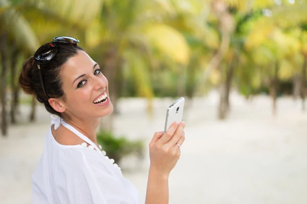 Mensajería de la mujer en el teléfono inteligente durante las vacaciones de viaje del Caribe —  Fotos de Stock