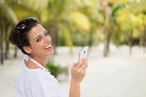 Mensajería de la mujer en el teléfono inteligente durante las vacaciones de viaje del Caribe — Foto de Stock