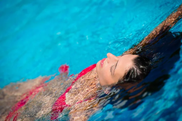 Женщина расслабляет летом в бассейне — стоковое фото
