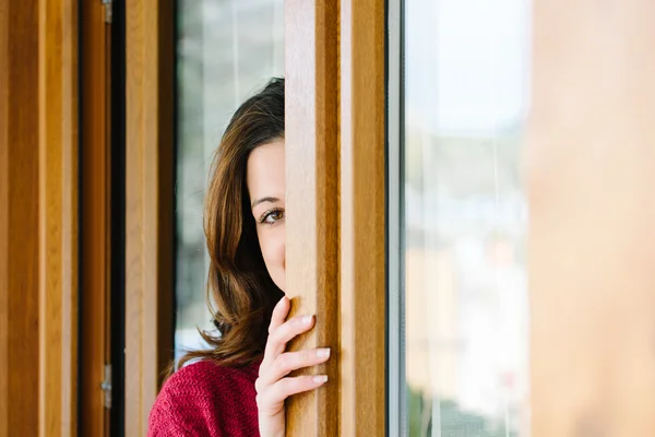 Donna giocherellona sbirciare attraverso la finestra di casa — Foto Stock