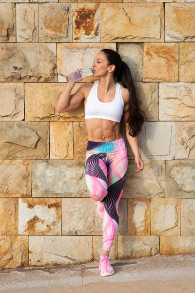 Fitness muscular woman resting and drinking water — Stock Photo, Image