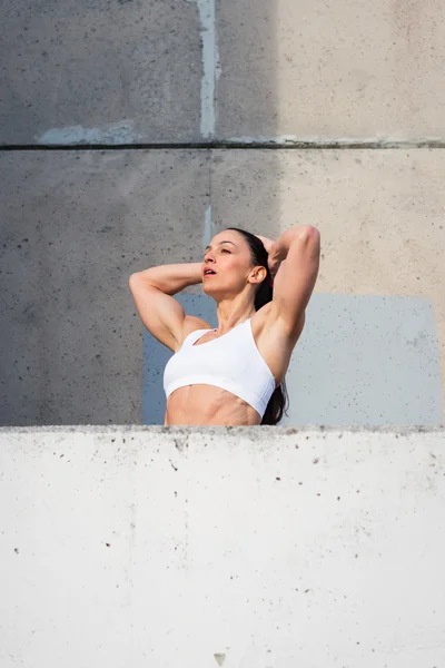 Mujer física muscular cansada descansando después del entrenamiento urbano —  Fotos de Stock