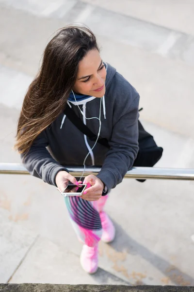 Femme fitness détendue écoutant de la musique sur smartphone — Photo