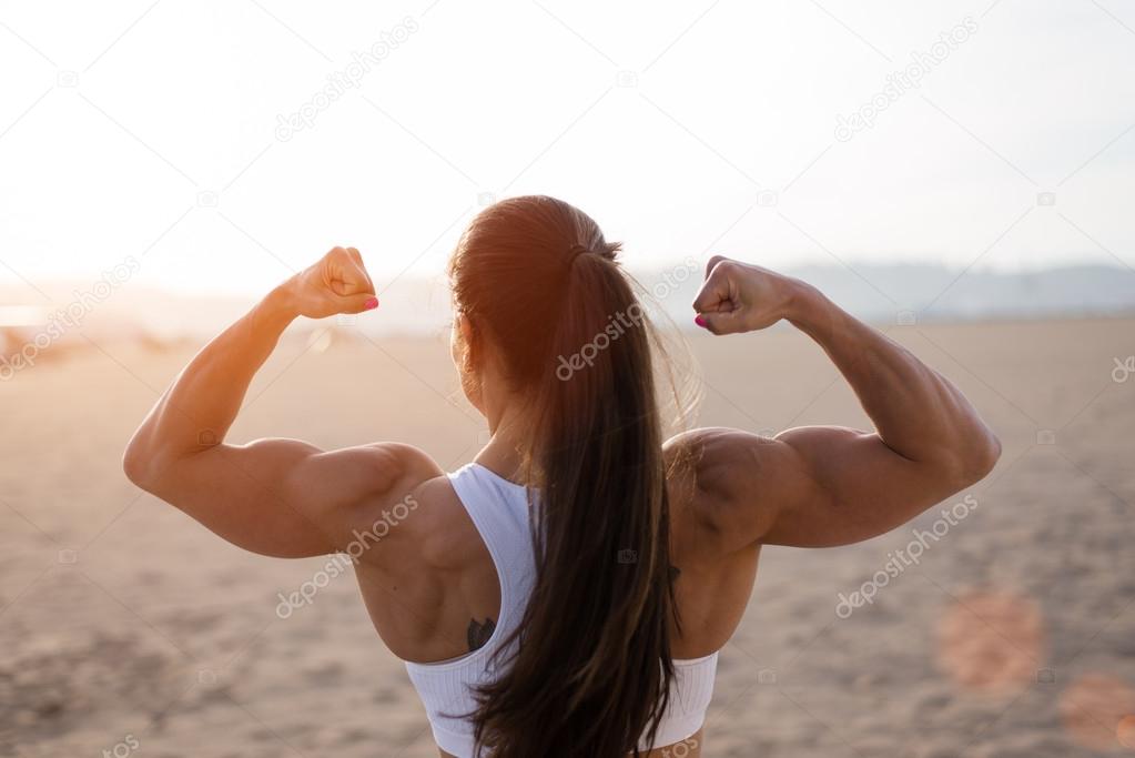 A Strong Girl With Big Muscular Arms On A Beach Stock Photo, Picture and  Royalty Free Image. Image 18043673.