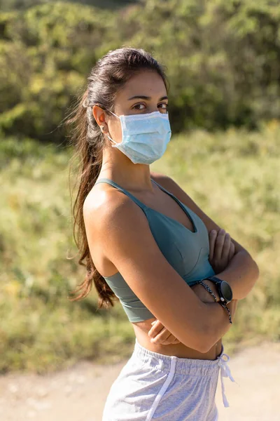 アウトドアワークアウトを実行する上で顔マスクを身に着けている若い女性のランナーに適した動機付けの肖像 コロナウイルスの健康パンデミック新しいフィットネスライフスタイル — ストック写真