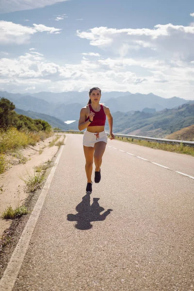 夏に山道を走る女性アスリートに適しています 夏の屋外でハードトレーニングスポーティ女性 — ストック写真