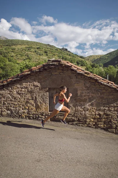 Female Athlete Running Rural Village Runner Exercison Road Mountain — Stockfoto