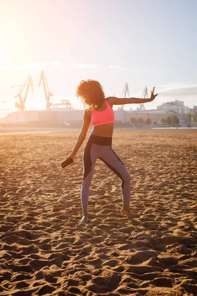 Young sporty fitness black woman on dancing at city beach. Healthy lifestyle and exercising.  Gijon, Asturias, Spain.