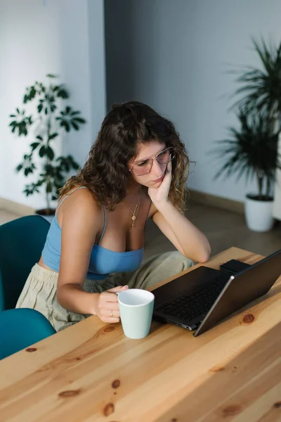 Evde Dizüstü Bilgisayarla Çalışan Kahve Içen Sıkıcı Genç Bir Kadın — Stok fotoğraf