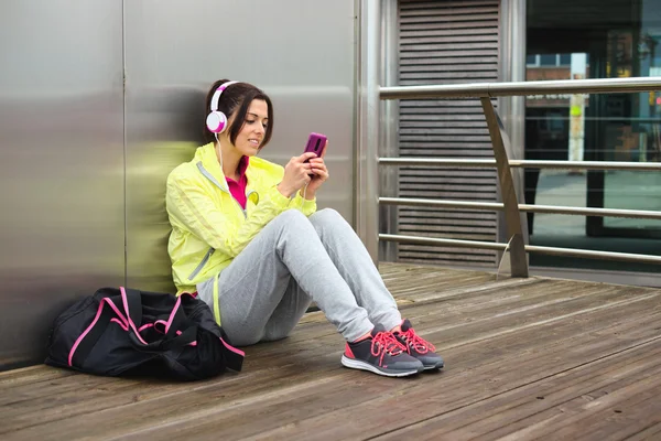 Kvinnliga idrottare SMS meddelande på smartphone — Stockfoto