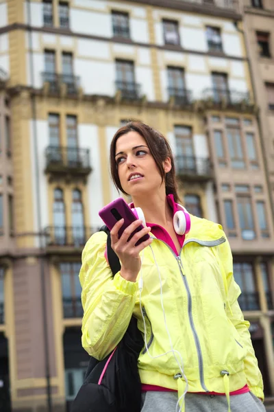 Sportig urbana kvinnan skicka SMS meddelande på smartphone i street — Stockfoto