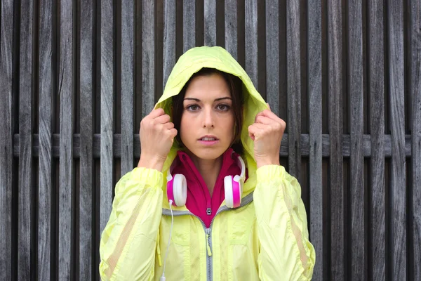 Serious female athlete wearing sport raincoat with hood — Stock Photo, Image