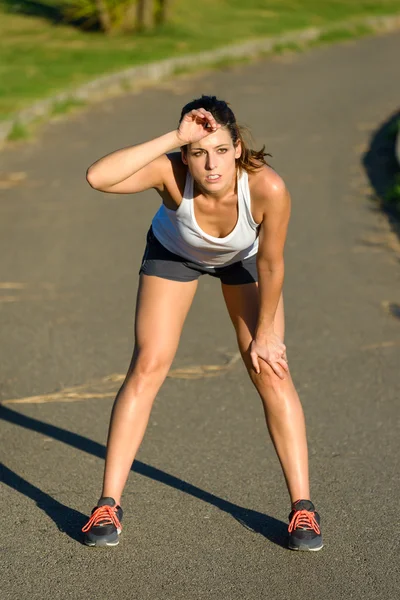 Müde Athletin legt Laufpause ein — Stockfoto