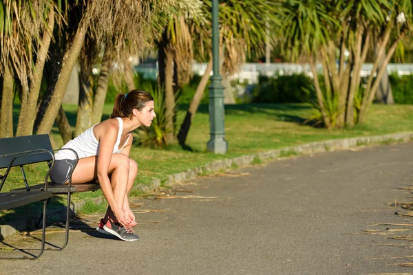 Θηλυκά αθλητής δένοντας αθλητισμού παπούτσια κορδόνια για τρέξιμο — Φωτογραφία Αρχείου
