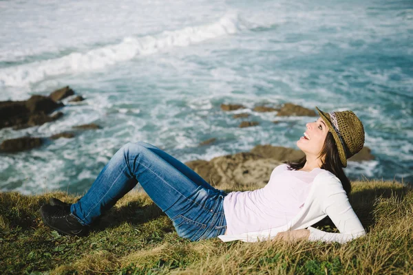 Joyful happy woman liying down towards the sea — Stock Photo, Image