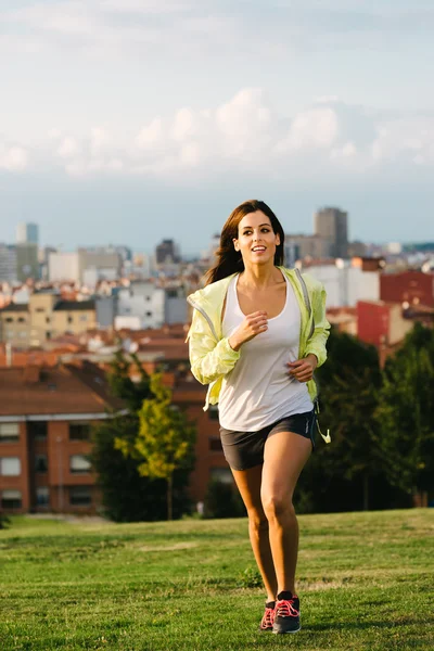 Donna bruna sportiva che corre nel parco cittadino — Foto Stock