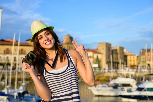 Successful happy tourist with camera by the harbor — Stock Photo, Image