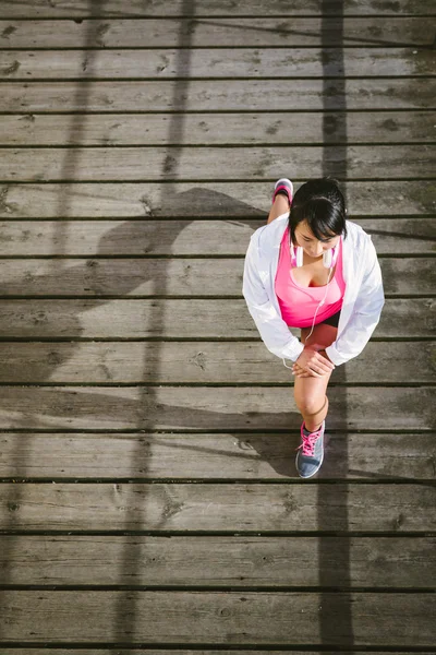 Genç kadın atlet çalıştırmadan önce germe — Stok fotoğraf