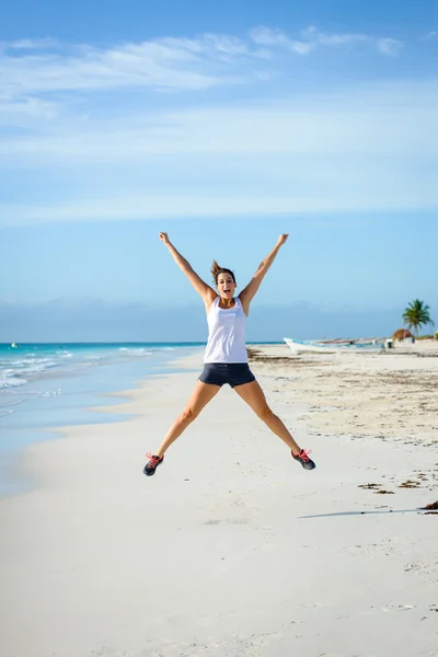 Sporty woman jumping at beach — Stock Photo, Image