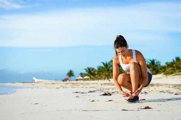 Sportowy kobieta gotowy do uruchomienia na tropikalnej plaży — Zdjęcie stockowe