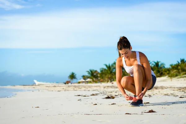 Mulher desportiva pronta para correr na praia tropical — Fotografia de Stock