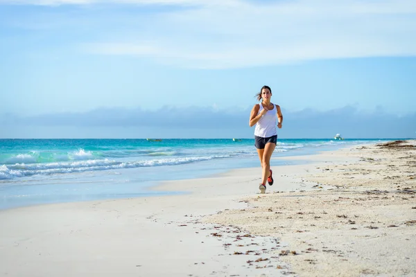 熱帯のビーチで走っている女性 — ストック写真