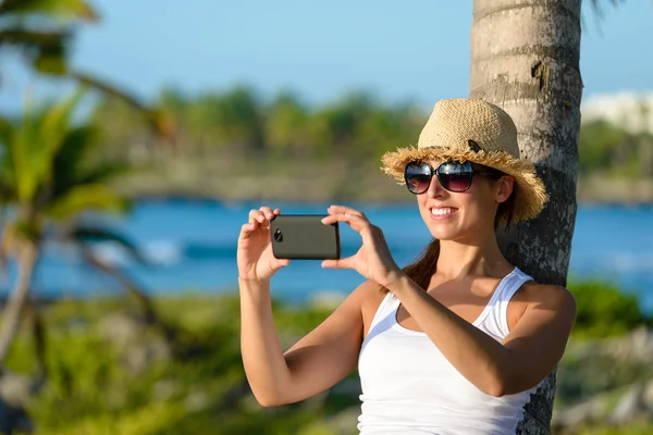 Woman on caribbean travel taking photo with smartphone — 图库照片