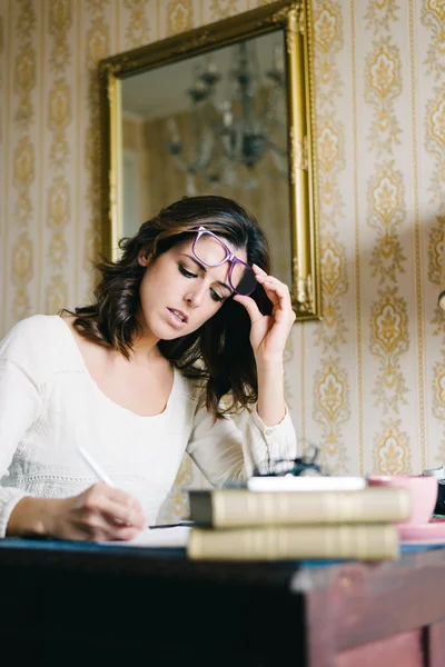 Woman writing and working at home — Stockfoto