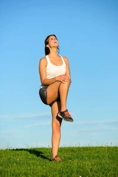 Female athlete suffering painful knee injury — Stock Photo, Image