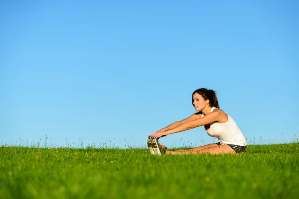 Sporty woman stretching legs outdoor — Stock Photo, Image