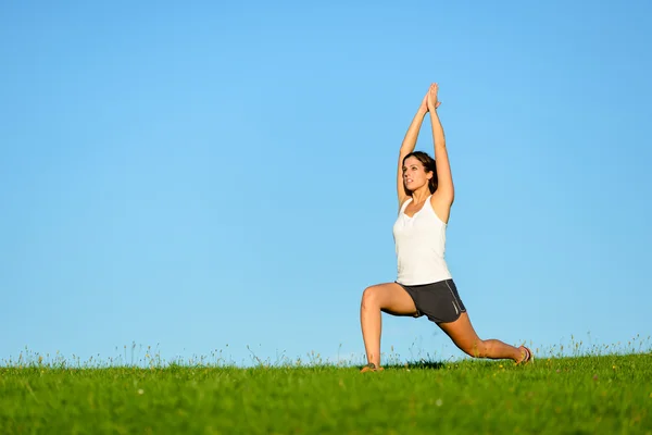 Sportliche Frau streckt Arme und Beine im Freien — Stockfoto