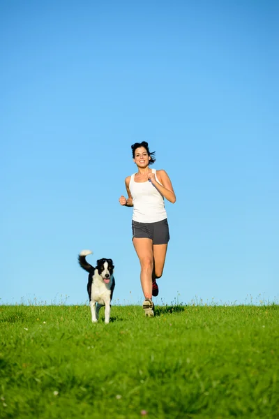 Sporty happy woman running with dog — 图库照片